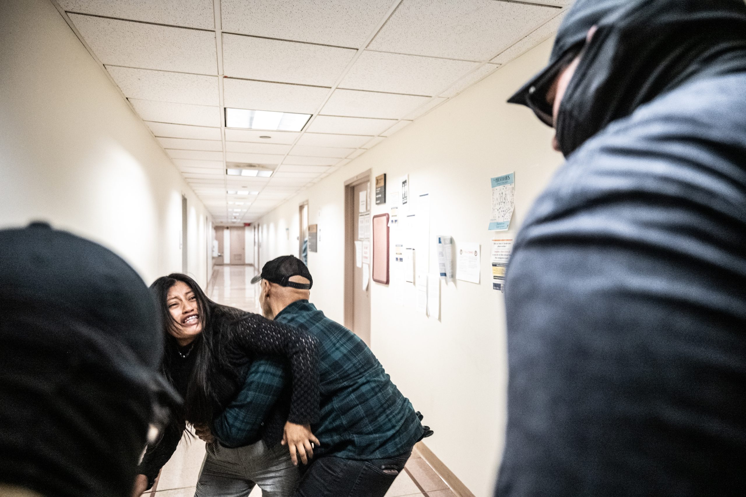 A federal agent restrains the wife of a detained man from Ecuador on Sept. 25 in New York City. The agent was later placed on leave.
