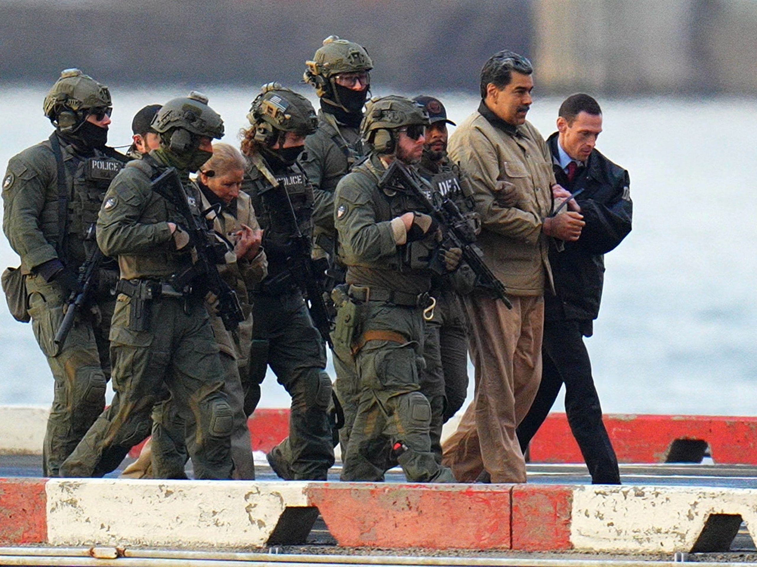 PHOTO: Nicolas Maduro and his wife, Cilia Flores, are seen in handcuffs after landing at a Manhattan helipad, escorted by heavily armed Federal agents, on Jan. 5, 2026, in New York.