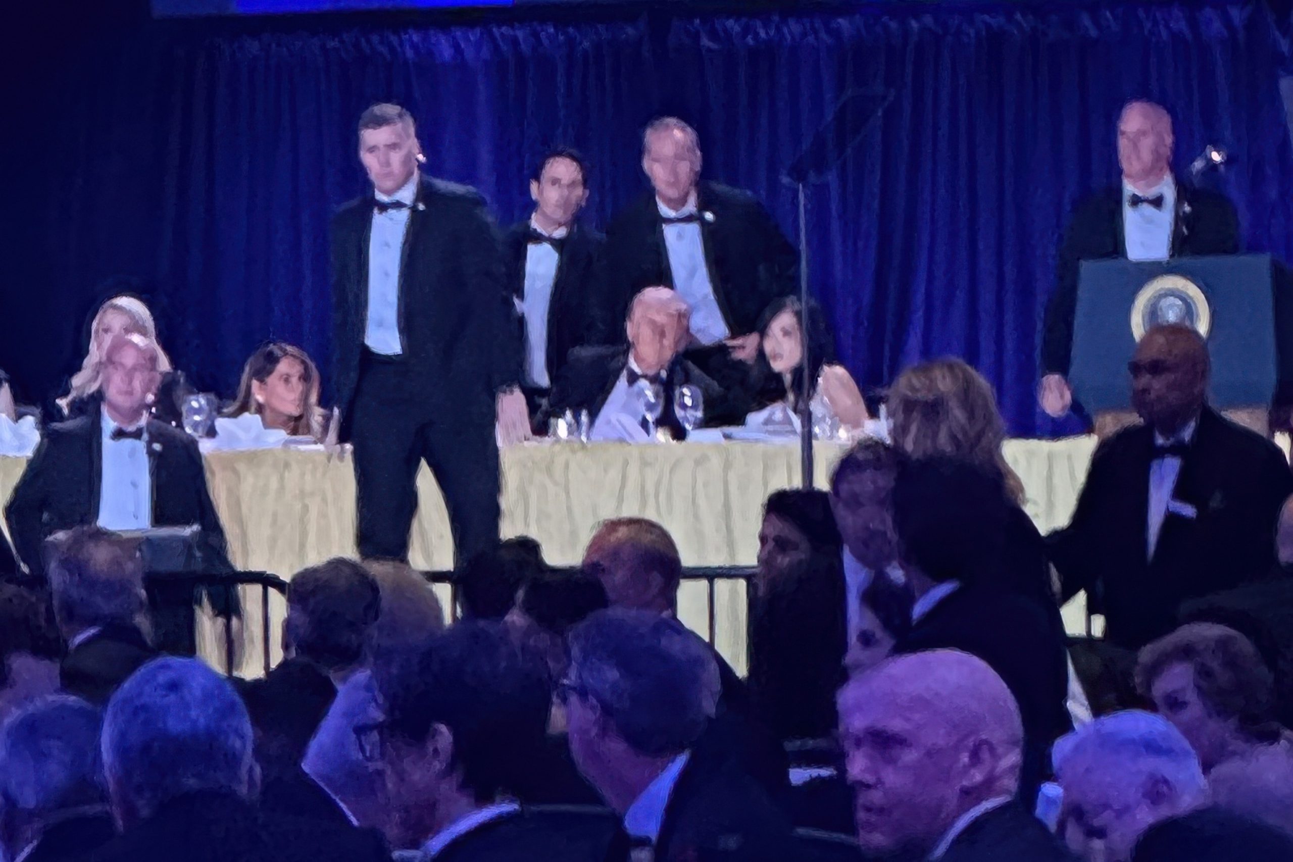 PHOTO: Secret Service agents surround President Donald Trump as mentalist, Oz Pearlman stands behind him before he was taken from the stage after a shooting incident during the White House Correspondents Dinner, April 25, 2026, in Washington.