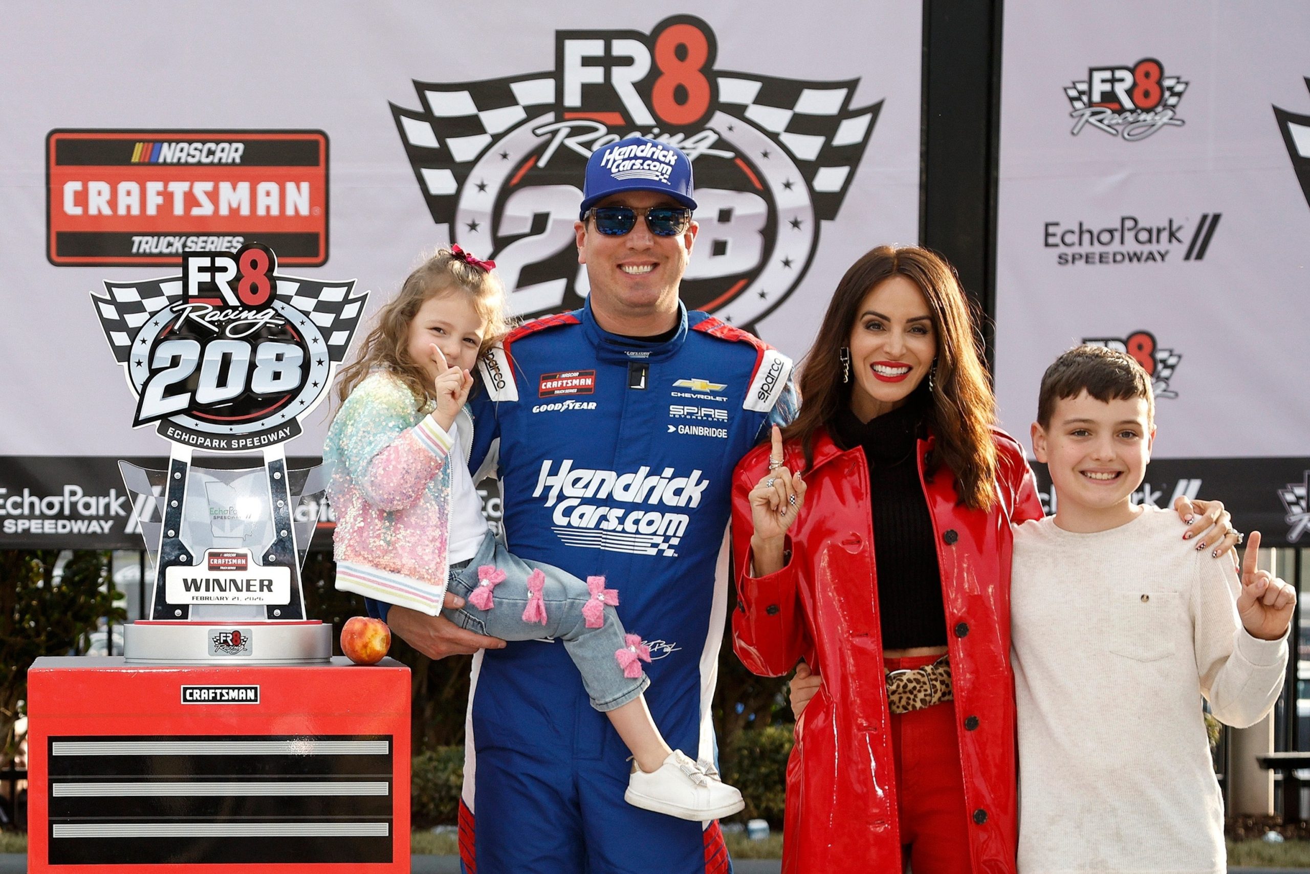 PHOTO: Kyle Busch celebrates with daughter, Lennix Busch, son, Brexton Busch, and wife, Samantha Busch, in victory lane after winning  the NASCAR Craftsman Truck Series Fr8 Racing 208 at Echo Park Speedway on Feb. 21, 2026, in Hampton, Georgia.