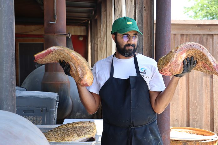 Zain Shafi prepares to put briskets in the smoker at Goldee