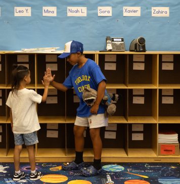 The first day of school: Bells, bikes, buses and big feelings Gerald Gomez-Reina high-fives new kindergartener Ian Patterson after they track down his cubby just before the first day of school at Micheltorena Street Elementary in Los Angeles.