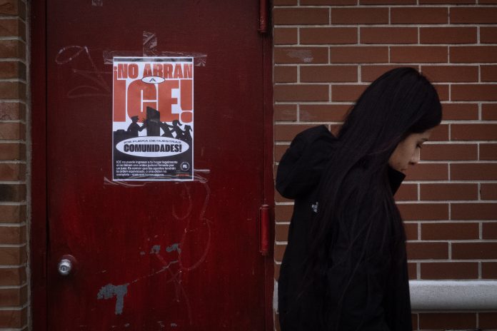 A poster calling on U.S. Immigration and Customs Enforcement (ICE) to get out of the community hangs on a door in the Little Village neighborhood on January 22, 2025 in Chicago, Illinois.