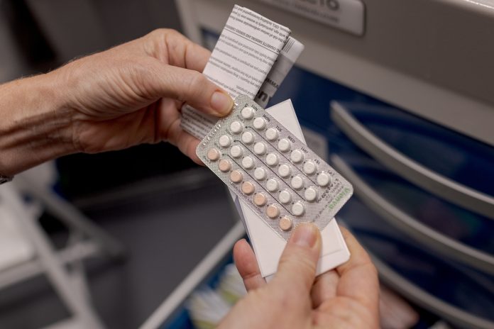 A nurse displays a set of birth control pills at Pima County Health Department