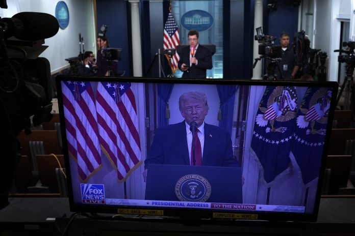 As seen on a TV monitor in the James S. Brady Press Briefing Room of the White House, President Trump speaks from the Cross Hall of the White House on April 1, 2026 in Washington, DC.