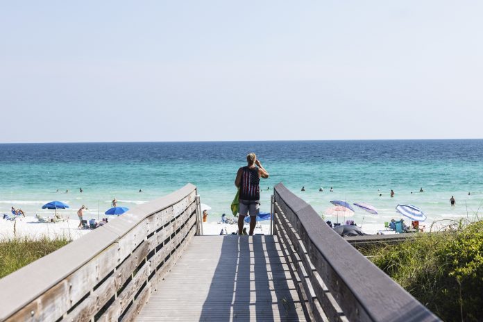 A beachgoer uses the boardwalk at Ed Walline Regional Beach Access off Scenic Highway 30A in Santa Rosa Beach, Fla. This stretch of the Gulf Coast has become "ground zero" in a battle between private property rights and public beach access.