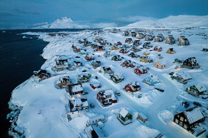 Houses covered in snow are seen on the coast of a sea inlet of Nuuk, Greenland, March 7, 2025.