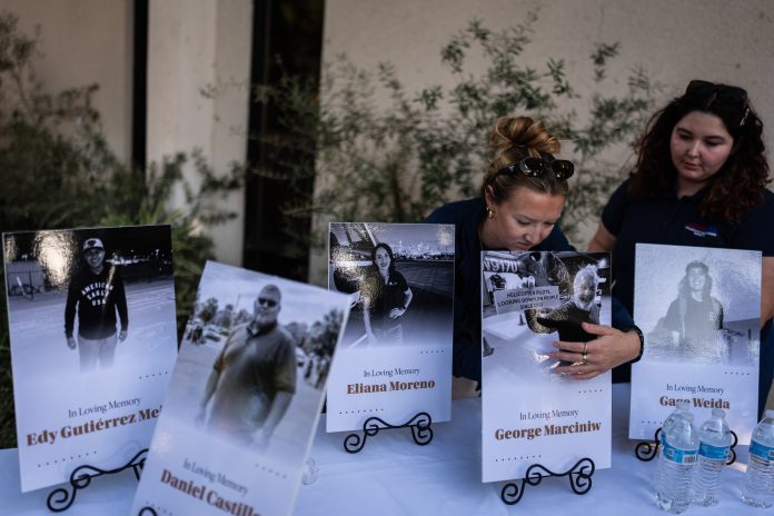Savannah Sampson, right, and Nicole Lewis, help set up a vigil for the victims of Tuesday