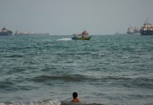 US military hits 3 Iranian oil tankers after saying Navy warships were targeted A swimmer remains near the shore as a motorboat passes commercial vessels anchored in the Strait of Hormuz off Bandar Abbas, Iran, on Friday.
