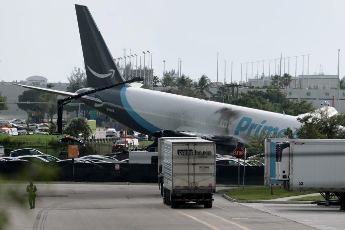 An Amazon cargo plane is seen after it crashed at Miami International Airport on Sunday in Miami, Florida. The Federal Aviation Administration said Prime Air Flight 7598 overran the runway while landing around 2 p.m. ET after departing from San Juan, Puerto Rico.