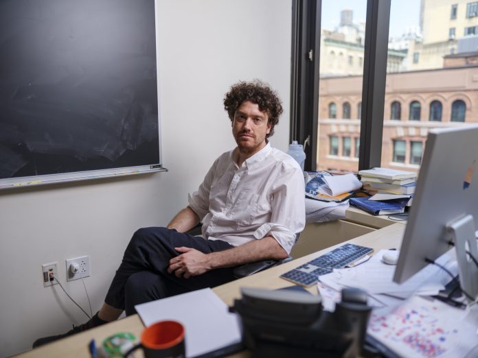 Tristan Buckmaster is a mathematician at New York University. He poses for a portrait in his office in Manhattan on September 11, 2026. Buckmaster and his collaborator Levent Alpöge have been working on the Navier-Stokes equations. They are clashing with OpenAI, which claims to have cracked the equations.