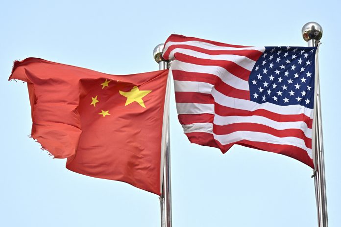 Chinese and US flags wave outside a technology company in Beijing, on April 17, 2025. (Photo by PEDRO PARDO/AFP via Getty Images)