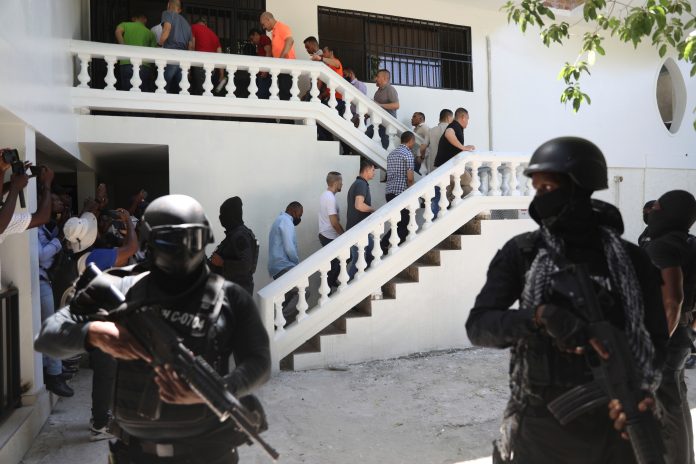 FILE - Colombians and Haitians who are accused of involvement in the 2021 assassination of Haitian President Jovenel Moise are escorted in handcuffs to their court hearing in Port-au-Prince, Haiti, May 26, 2025.