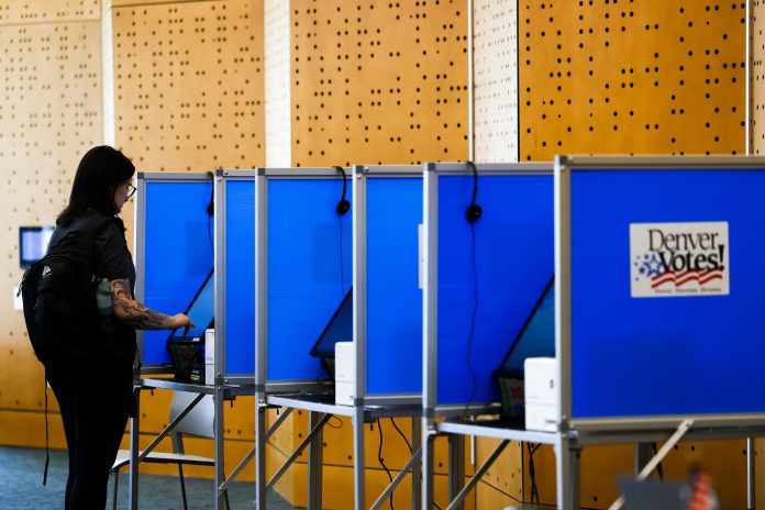 A voter casts her ballot in Colorado