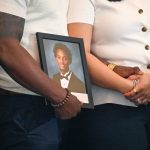 Questions remain after grand jury declines indictment in Nolan Wells’ death Christine Wonsley and Elmore Wonsley, mother and stepfather of Nolan Wells, stand on a stage with a photo of their son as they appear at the National Urban League