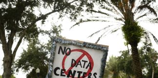 Voters are fed up with data centers. Both parties are trying to cash in for midterms A person holds signs during a nationwide protest against AI data center expansion in New Port Richey, Florida on July 18, 2026.
