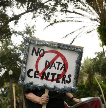 Voters are fed up with data centers. Both parties are trying to cash in for midterms A person holds signs during a nationwide protest against AI data center expansion in New Port Richey, Florida on July 18, 2026.